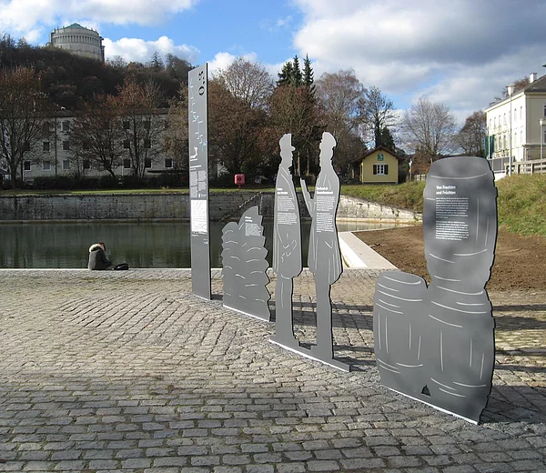 Stele Figuren mit Historie des Ludwig-Donau-Main-Kanals. 
Im Hintergrund: Schleusenwärtergehilfenhäuschen.
