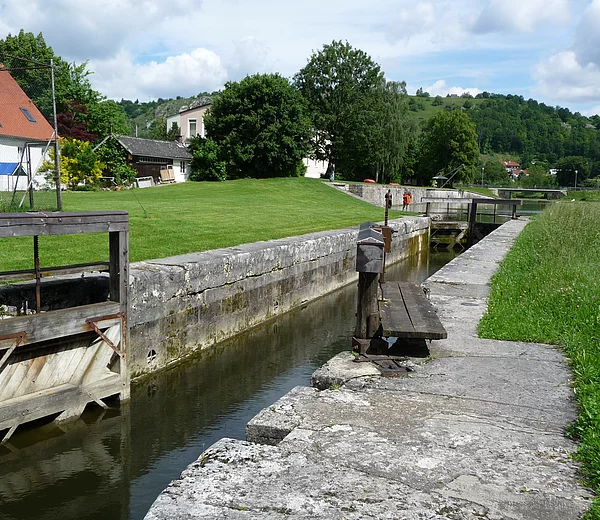 Blick auf die Schleusenkammer und -tore der Schleuse 1. Im Hintergrund der Kanalhafen Kelheim.