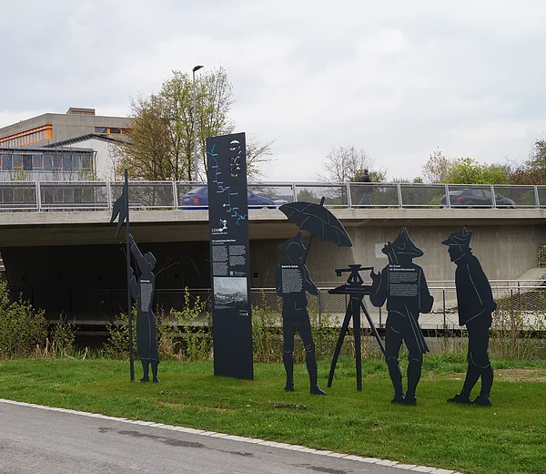 Die Figurengruppe im Parc d’Issoire in Neumarkt stellt eine historische Vermessungsszene aus der Bauzeit des Ludwig-Donau-Main-Kanals dar.