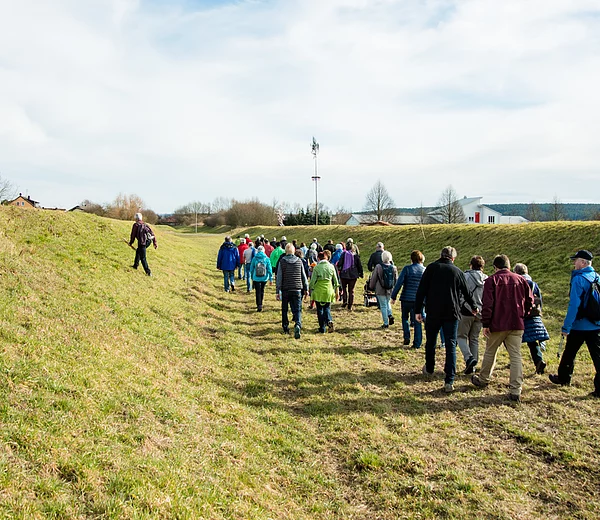 Wandergruppe durchquert das heute trockene Kanalbett des historischen Ludwigkanals in Neuses a.d.R. bei einer Wanderung auf dem Sieben-Flüsse-Wanderweg