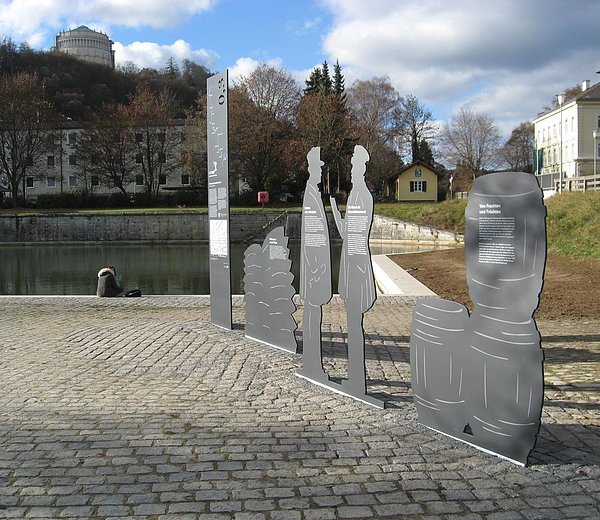 Stele Figuren mit Historie des Ludwig-Donau-Main-Kanals. 
Im Hintergrund: Schleusenwärtergehilfenhäuschen.